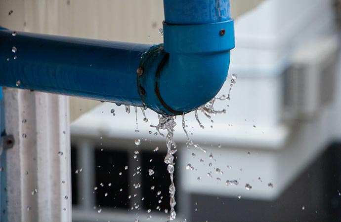 closeup view of leaked and splash water from the blue pipe